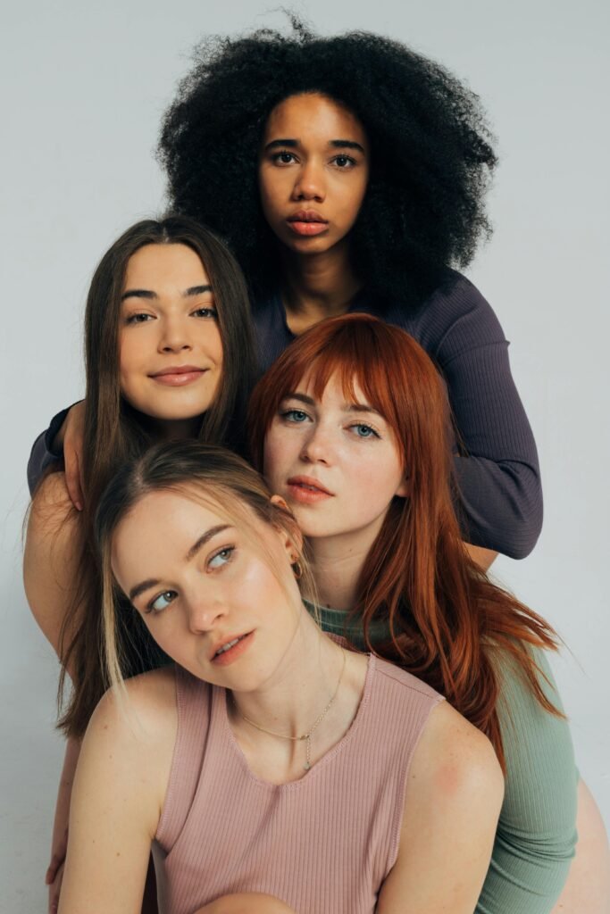 Portrait of four diverse women embracing, showcasing friendship and diversity.